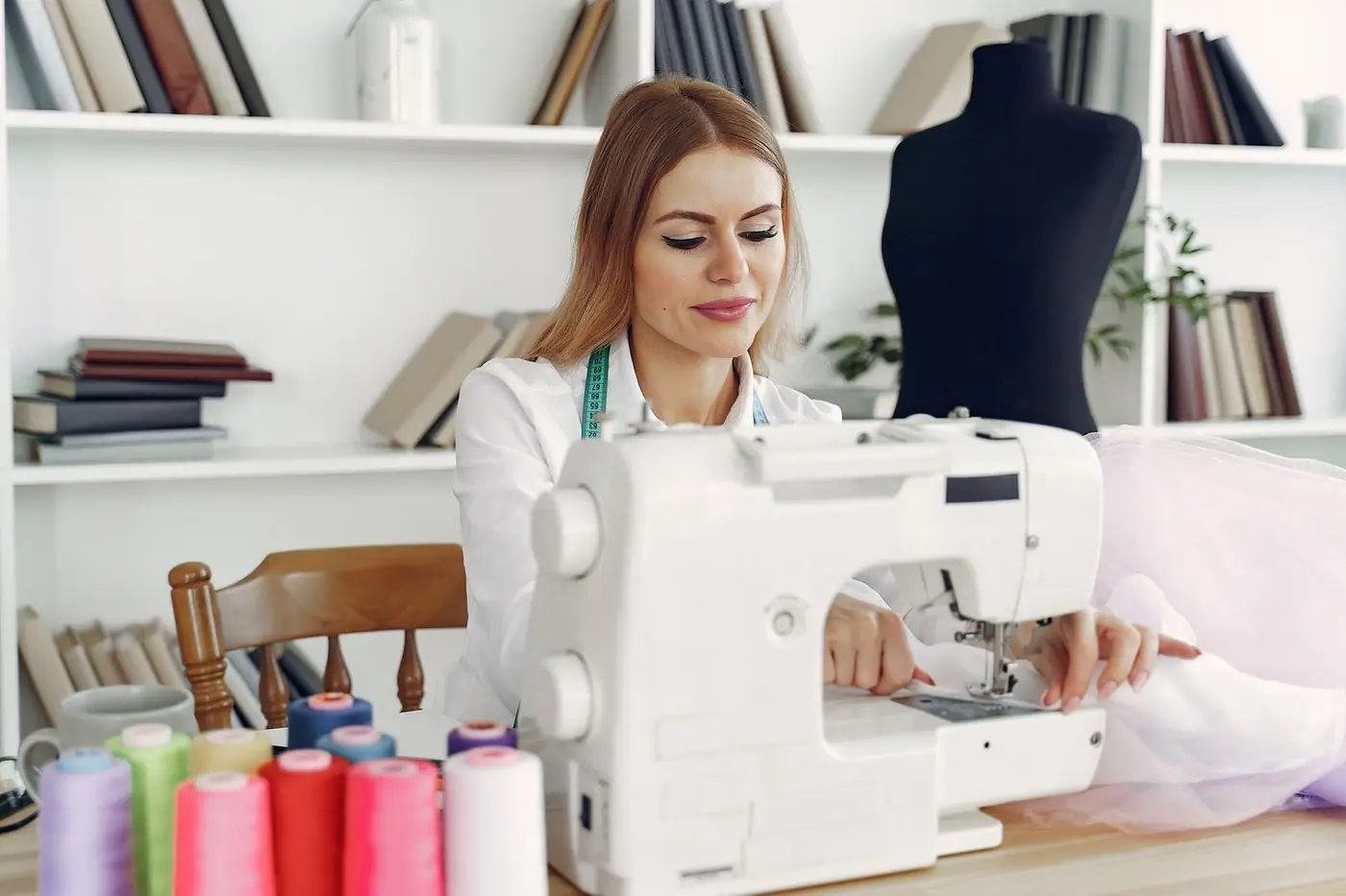 Woman sewing in a creative studio using a sewing machine