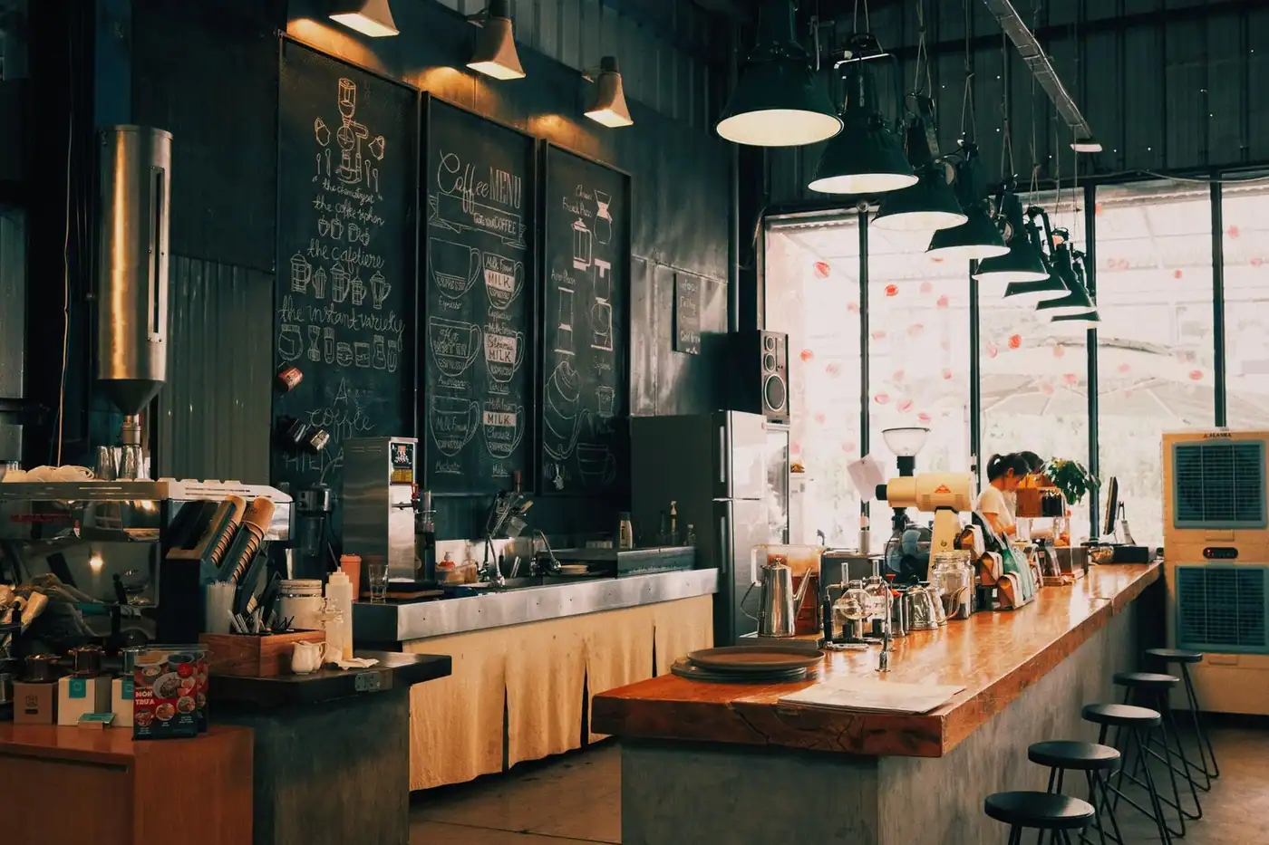 A warm, rustic café with a wooden counter and chalkboard menu