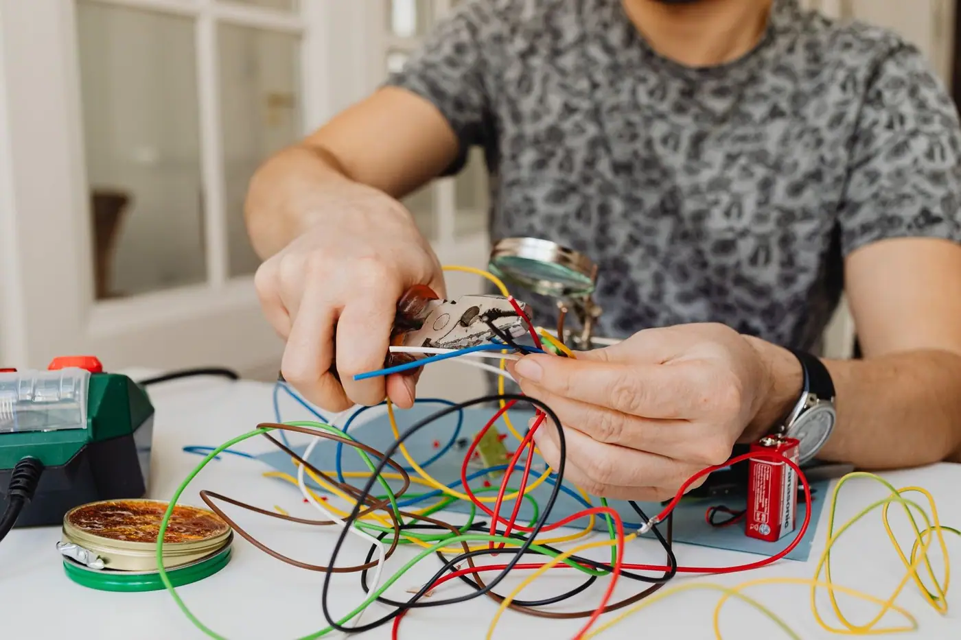 Pliers cutting through colourful electrical wires