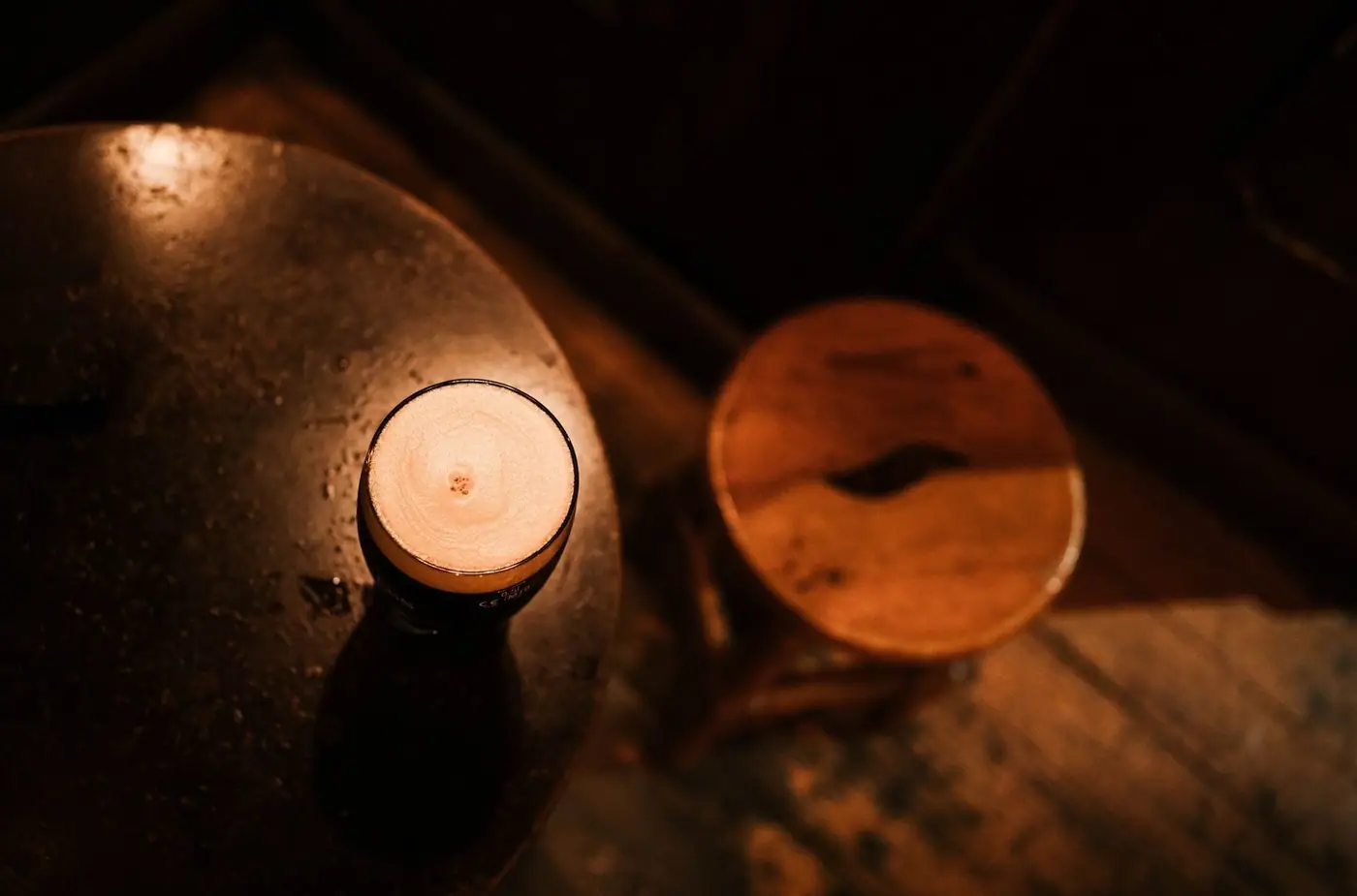 A freshly poured drink on a wooden table in warm light