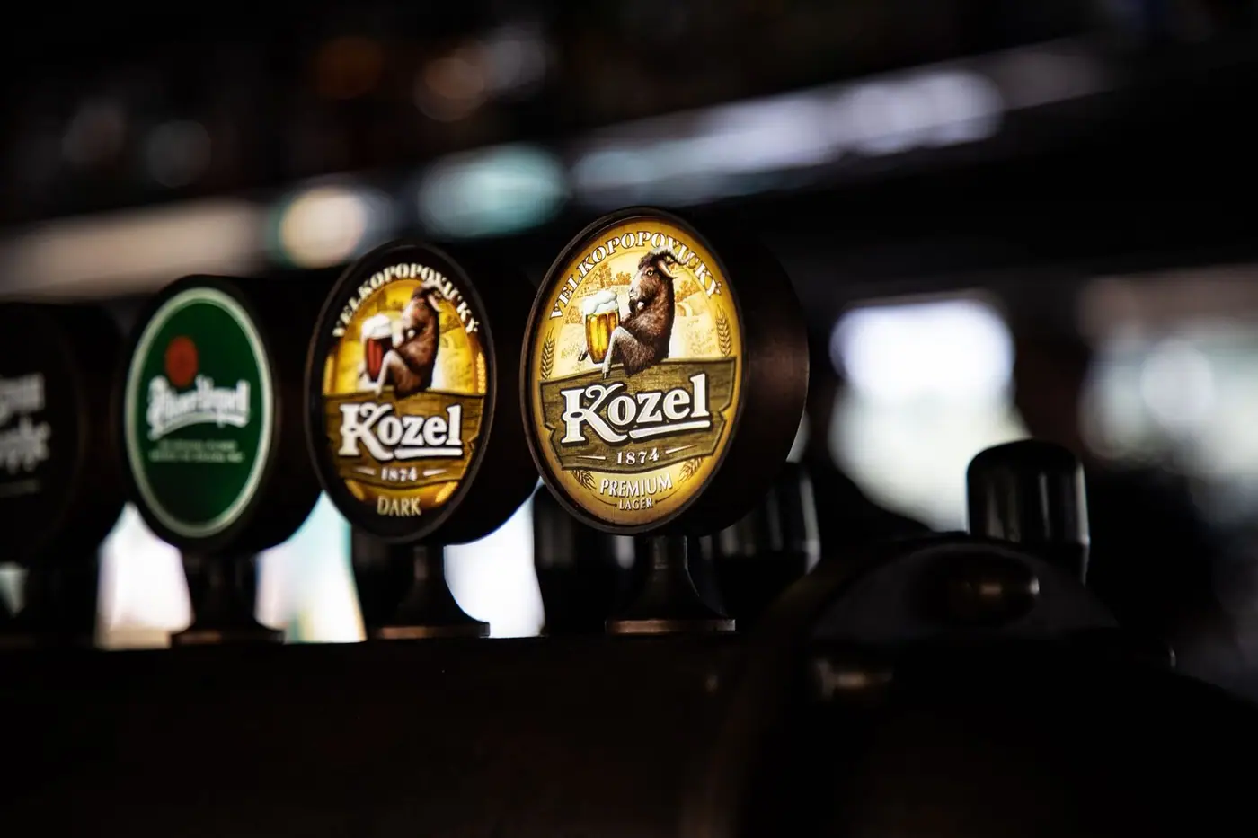 Close-up of beer taps in a dimly lit bar