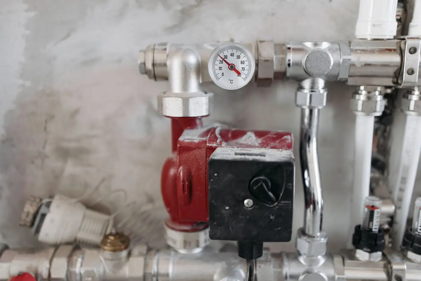 Close-up of an industrial plumbing system with a pressure gauge and steel pipes