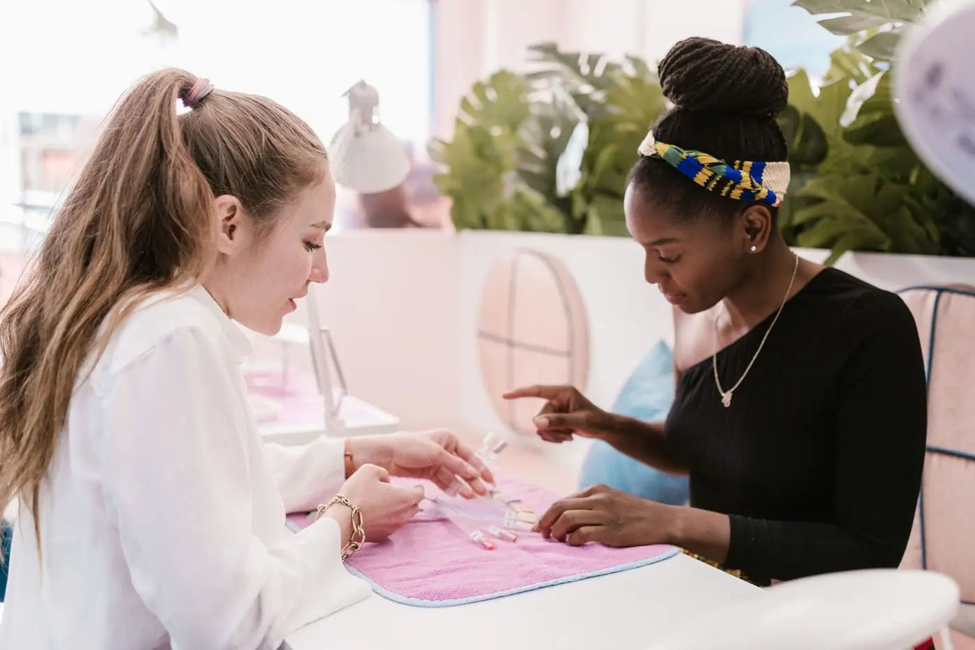 Two women selecting nail polish colours at a chic nail salon