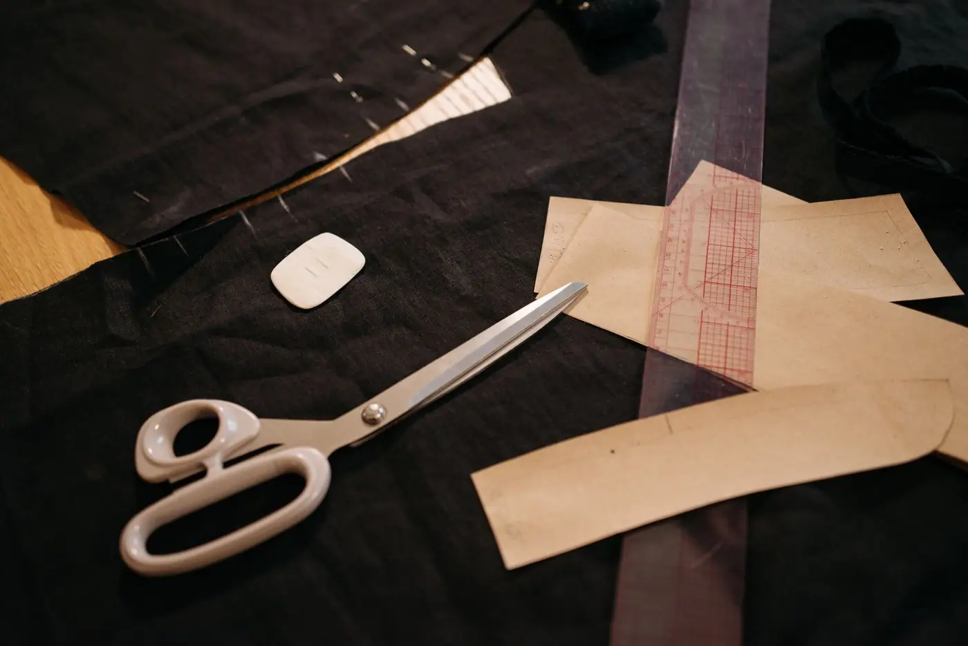 Close-up of tailoring tools: scissors, fabric and patterns on a workbench