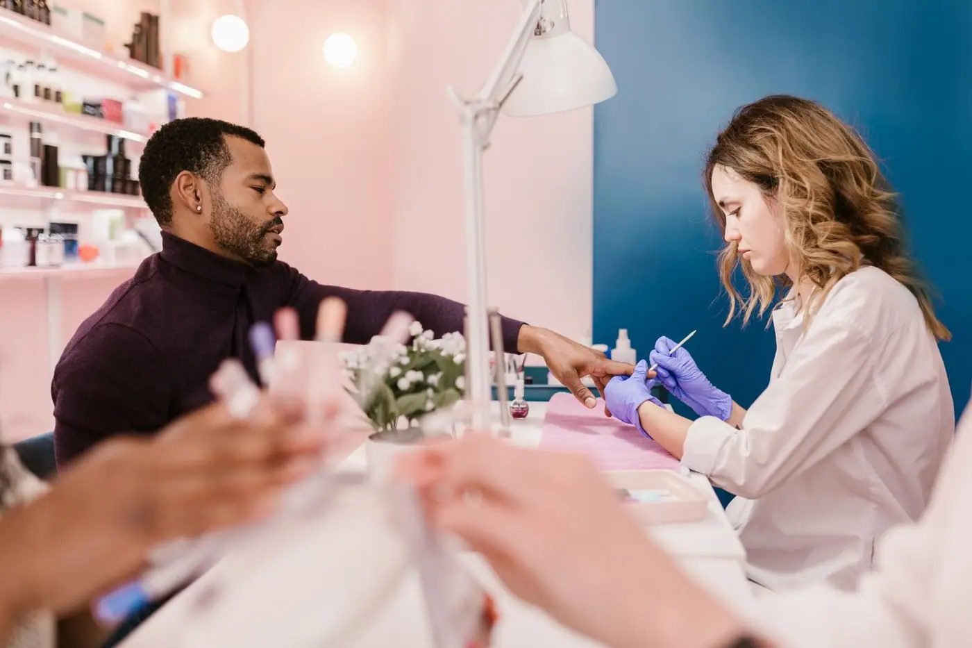A nail technician giving a man a manicure in a stylish, modern salon