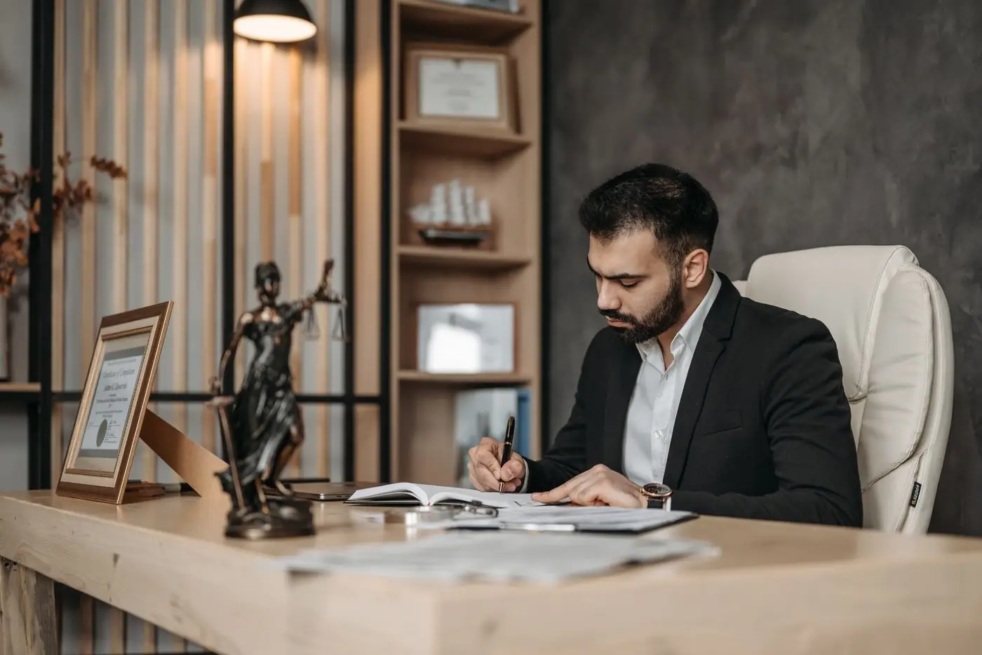 A lawyer at a desk writing and reviewing legal documents