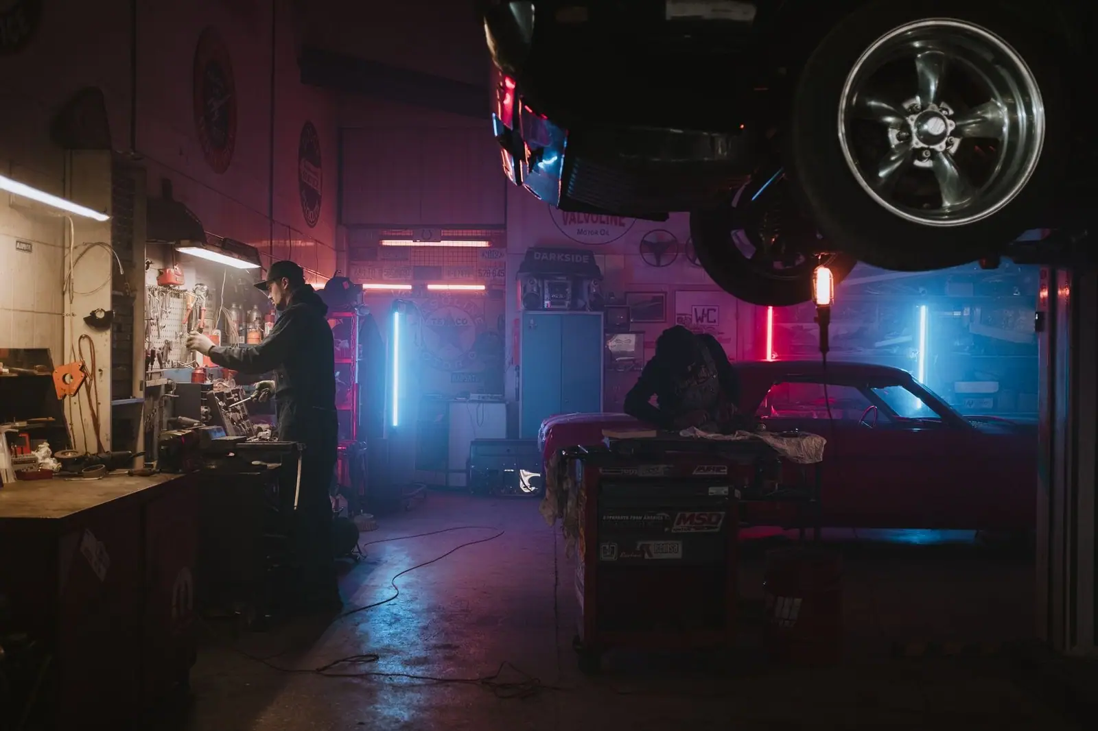 Mechanics working in a neon-lit garage