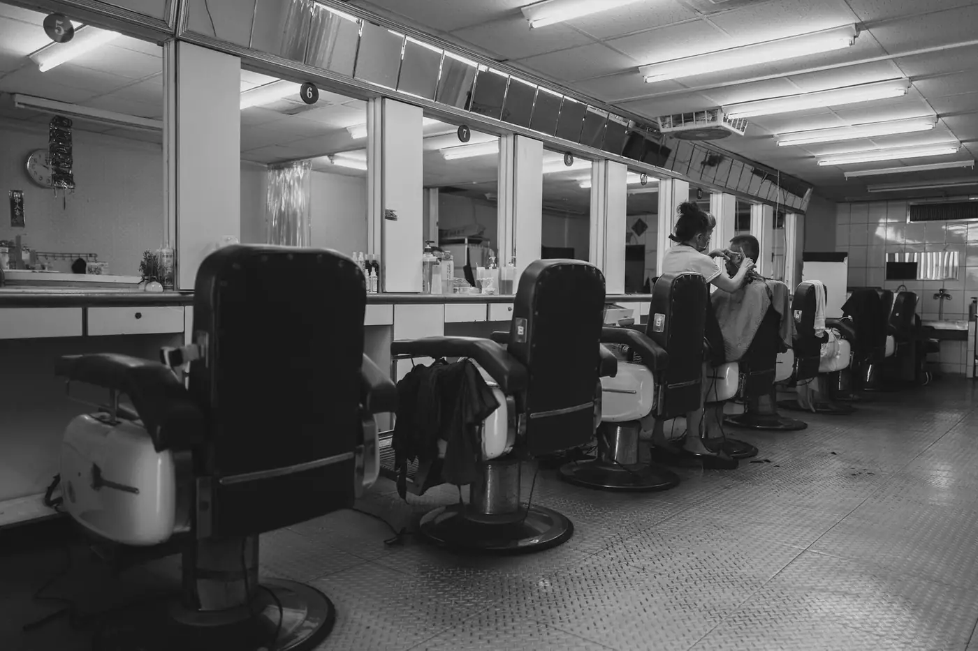 Black and white photo of vintage barbershop styling chairs and mirrors