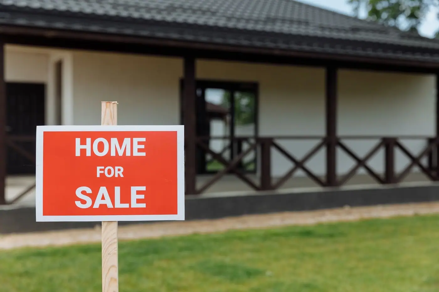 A charming home for sale with a spacious lawn and classic veranda.