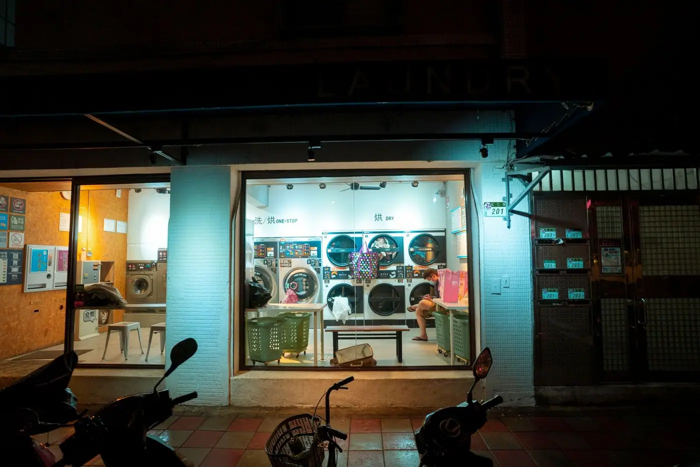A cosy urban laundromat at night with a welcoming interior and modern washing machines