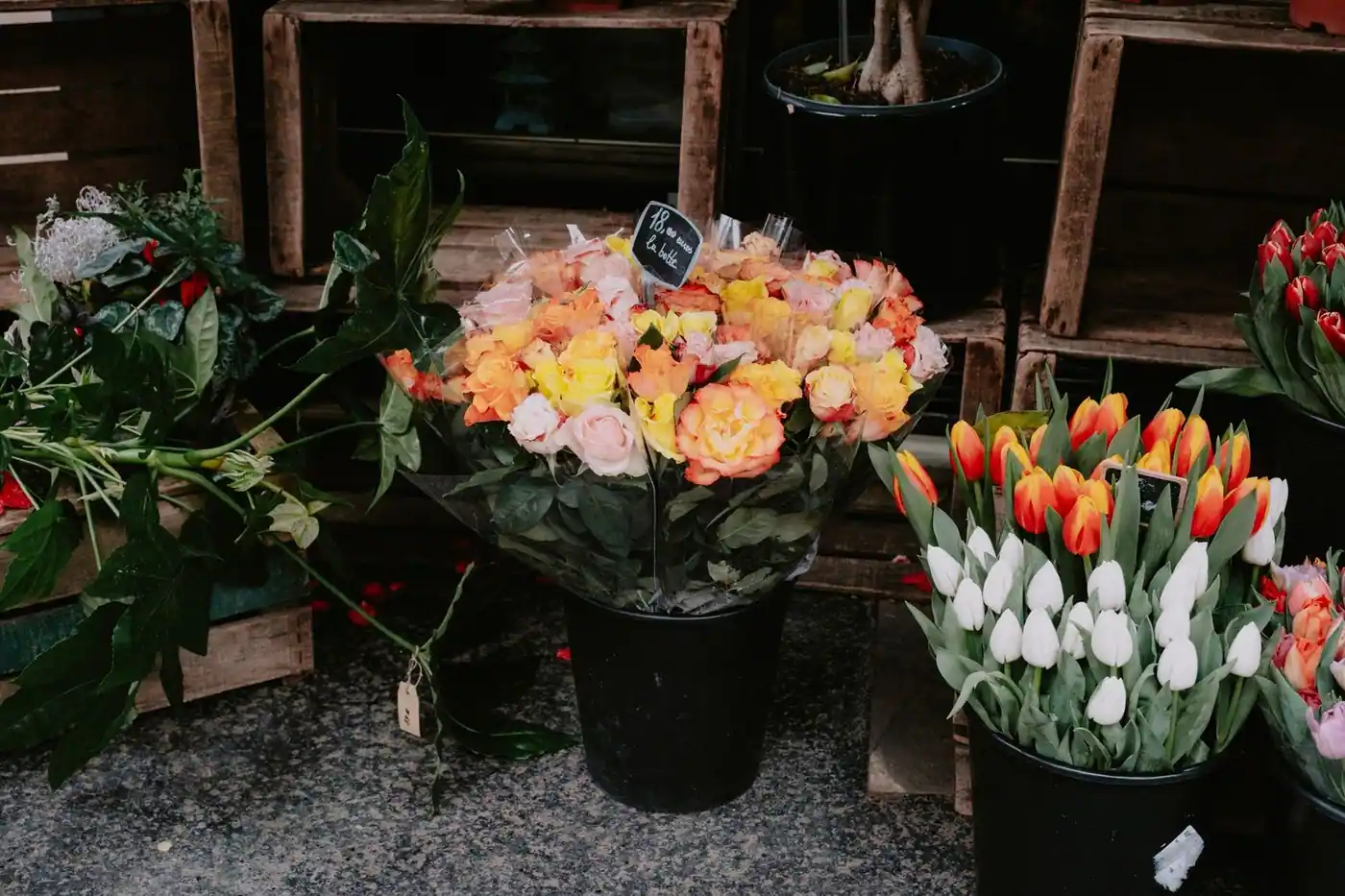 Bouquets of roses and tulips on display at a street market