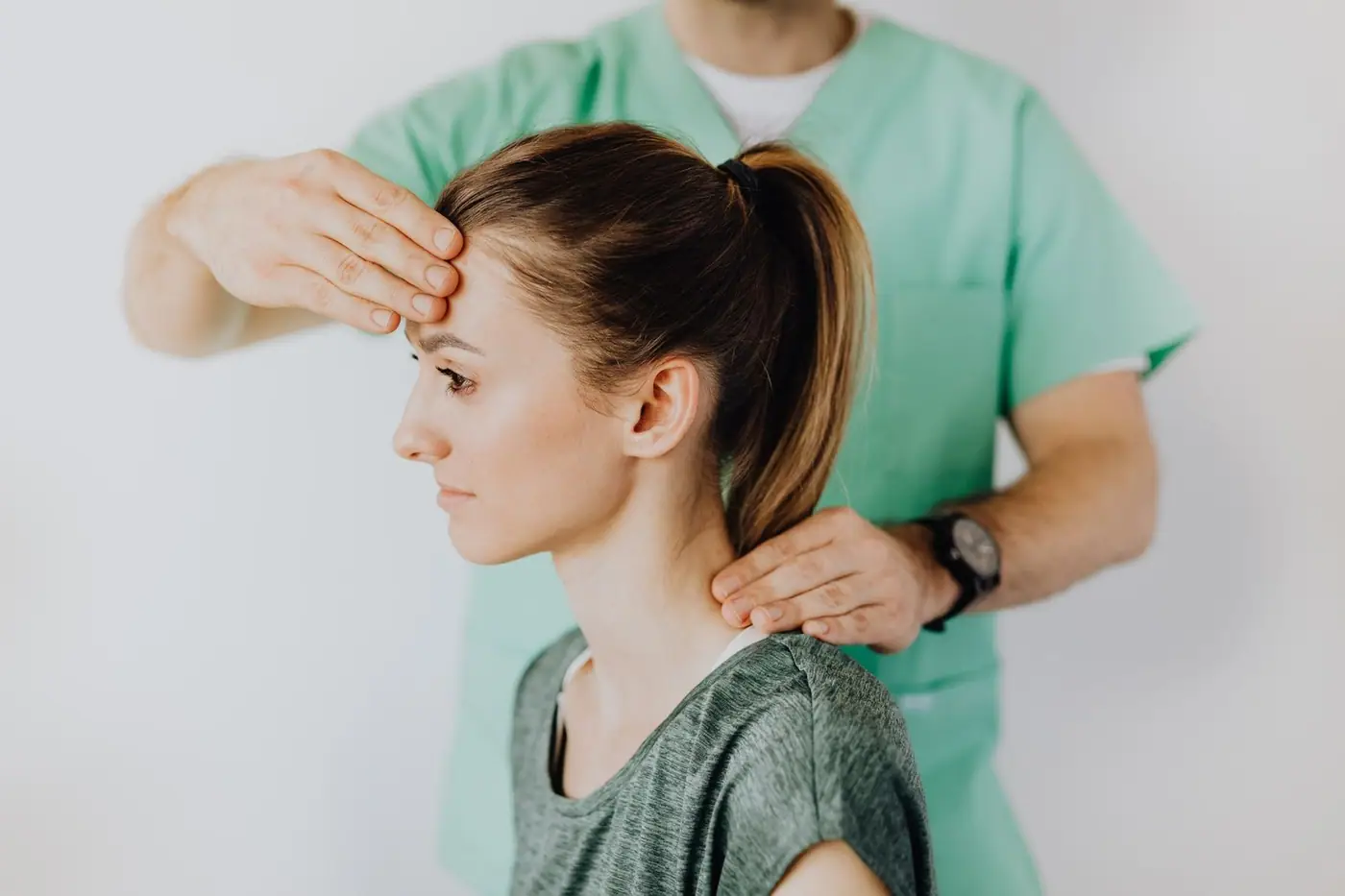 Massage therapist performing a head and neck massage to relieve sore neck tension