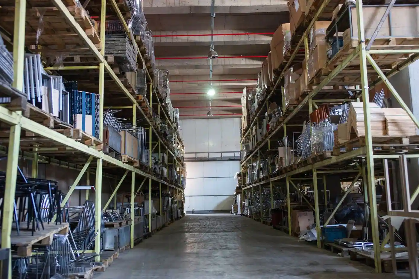 Wide aisle in a warehouse lined with industrial metal shelving