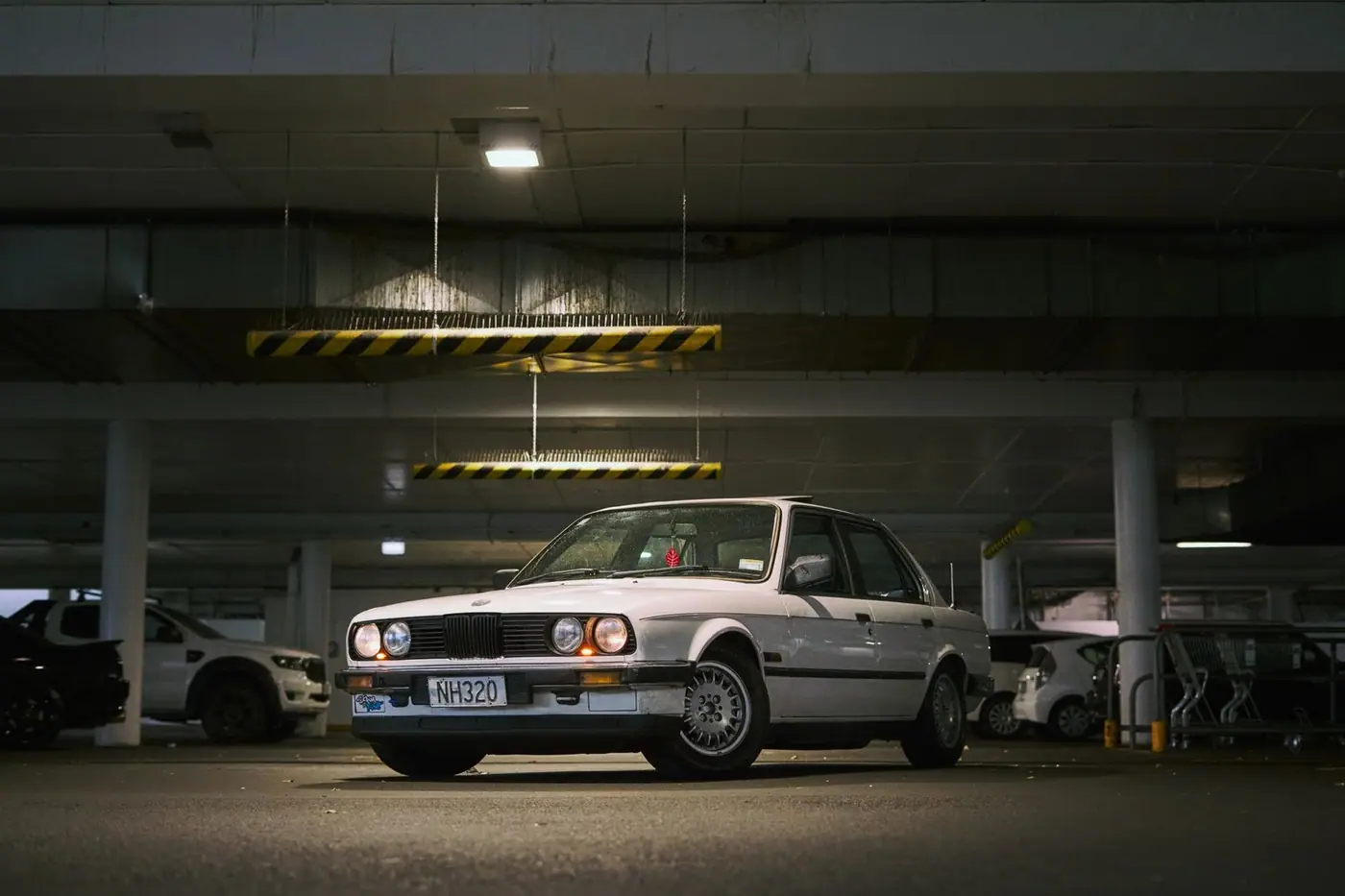 Classic car parked indoors under moody lighting