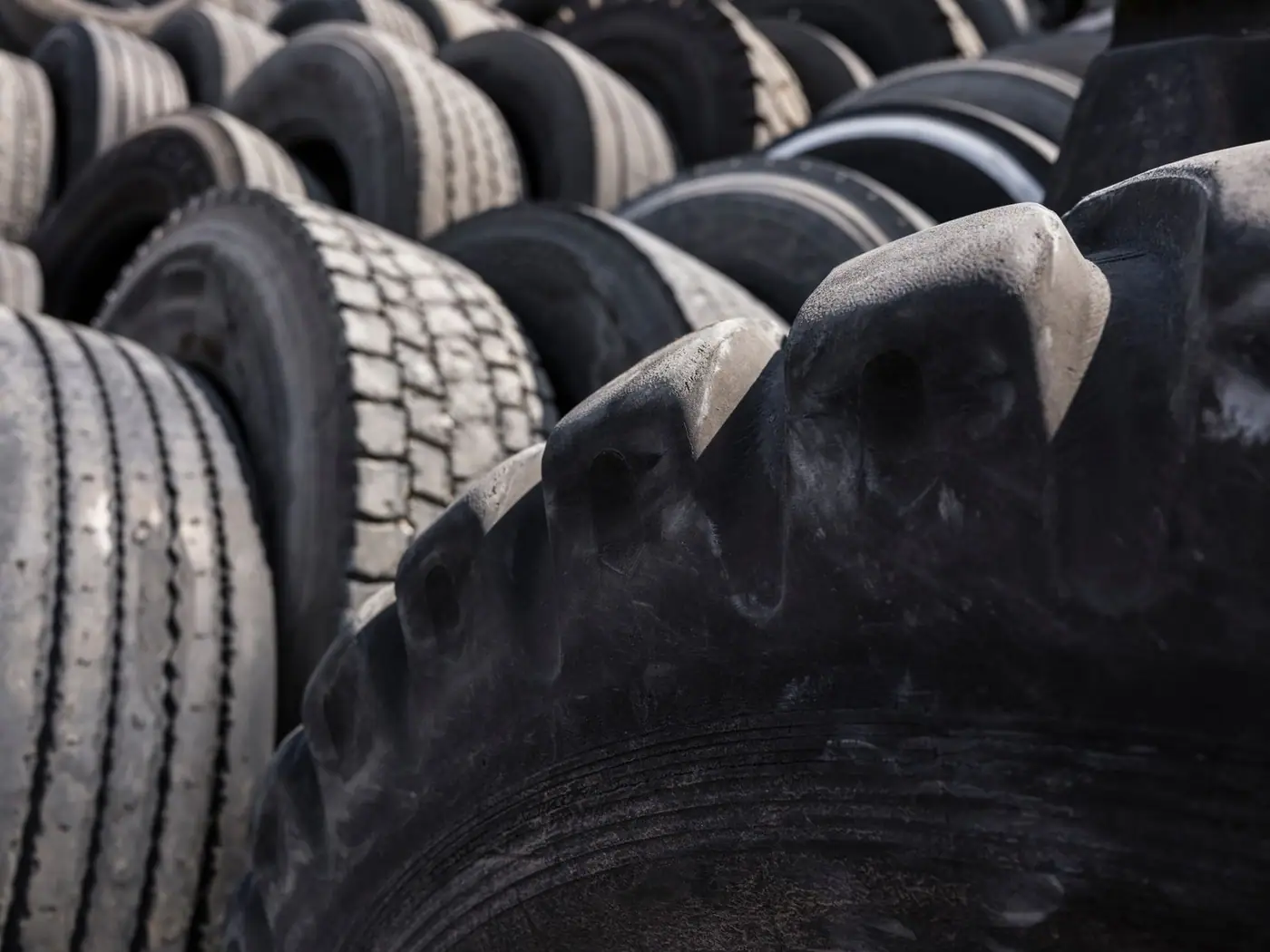 Close-up of a pile of used tyres in an outdoor industrial setting
