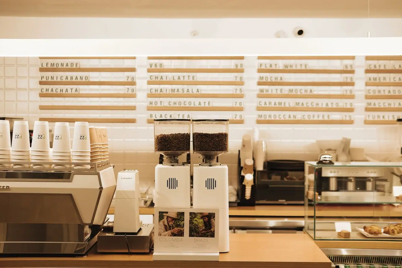 Cafe counter with coffee machines, grinders and a menu board