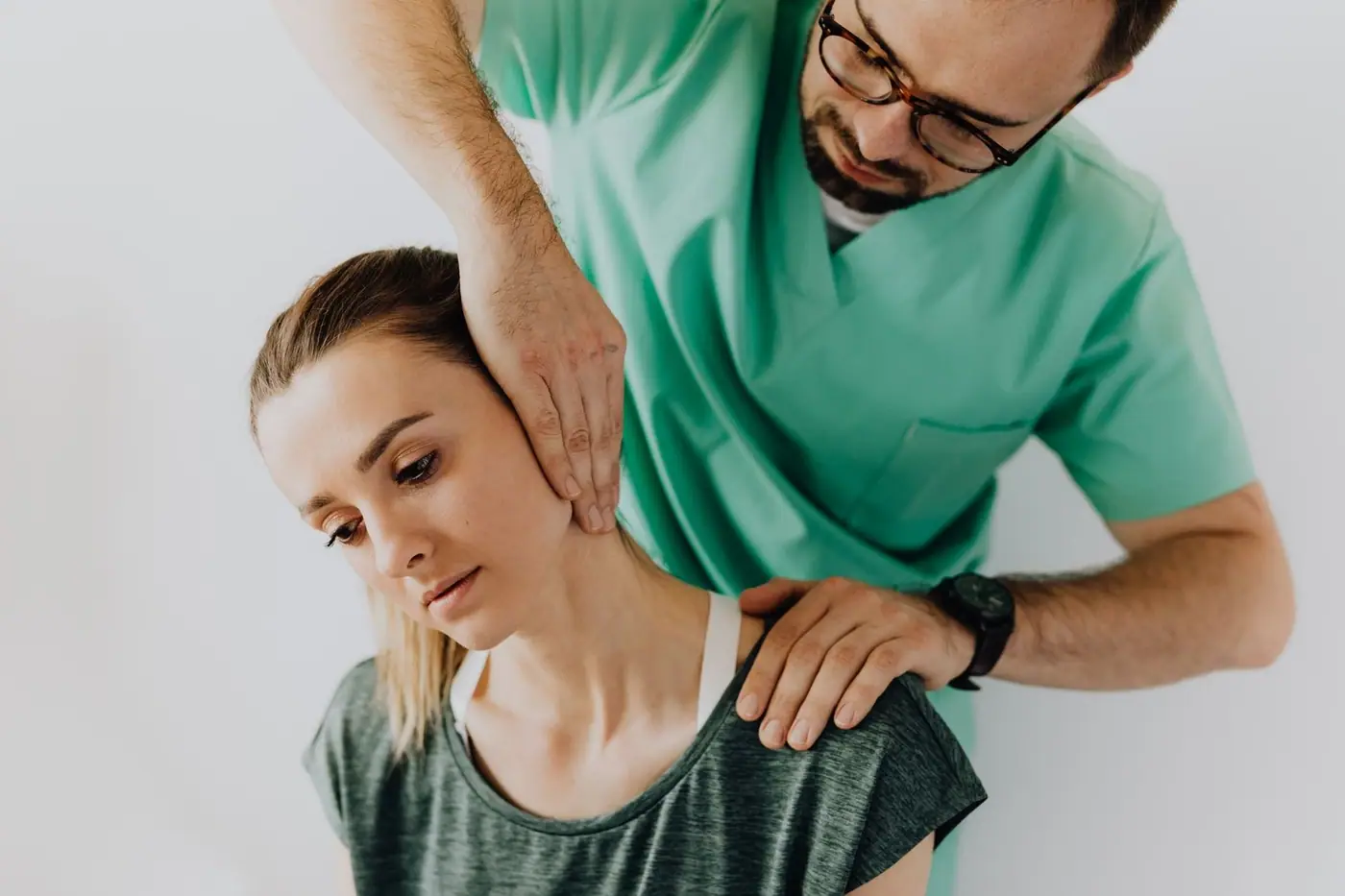 Hands gently massaging a woman's neck to ease stiff muscles