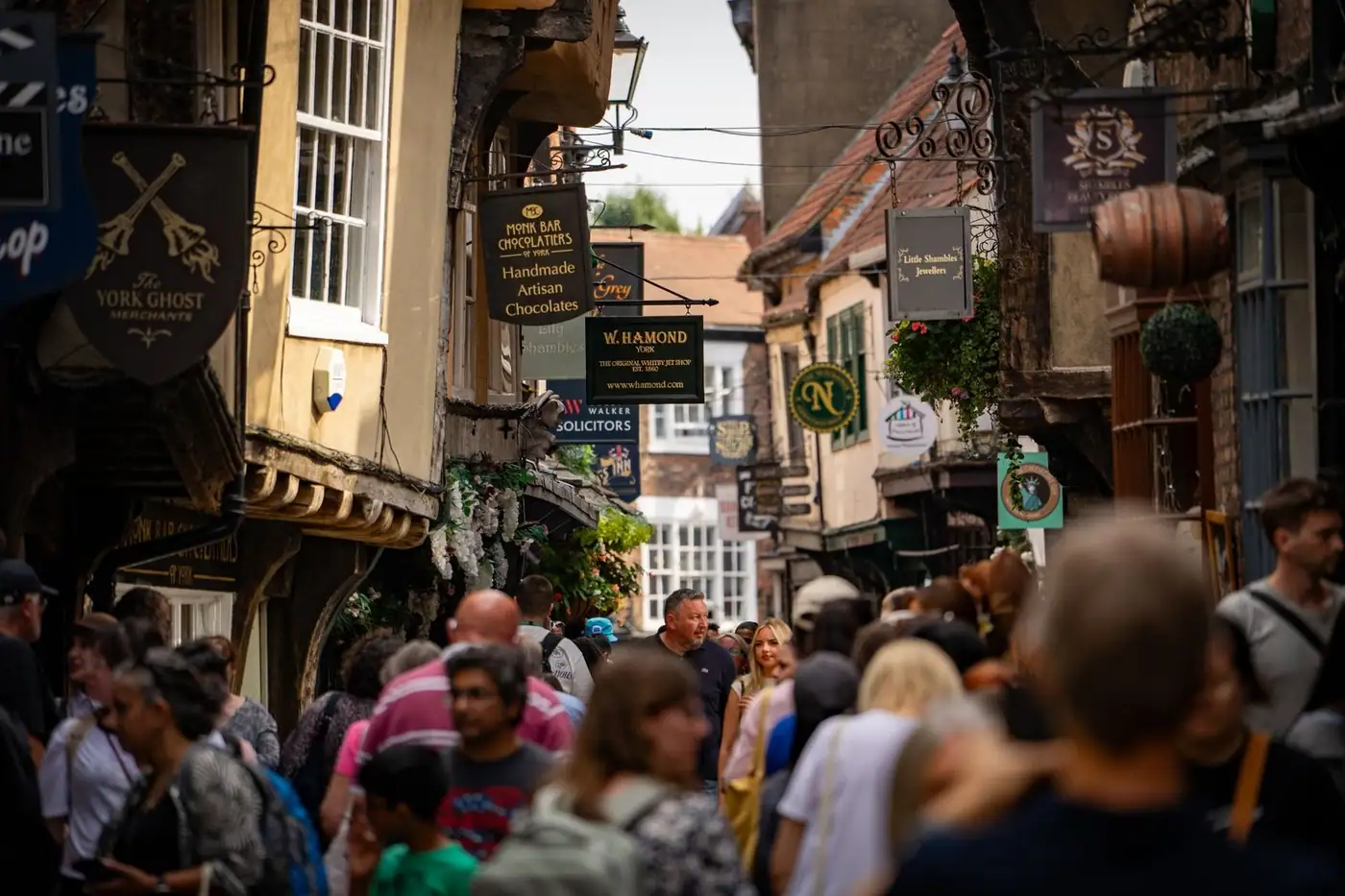 The historic Shambles street in York, filled with lively crowds and shop signs