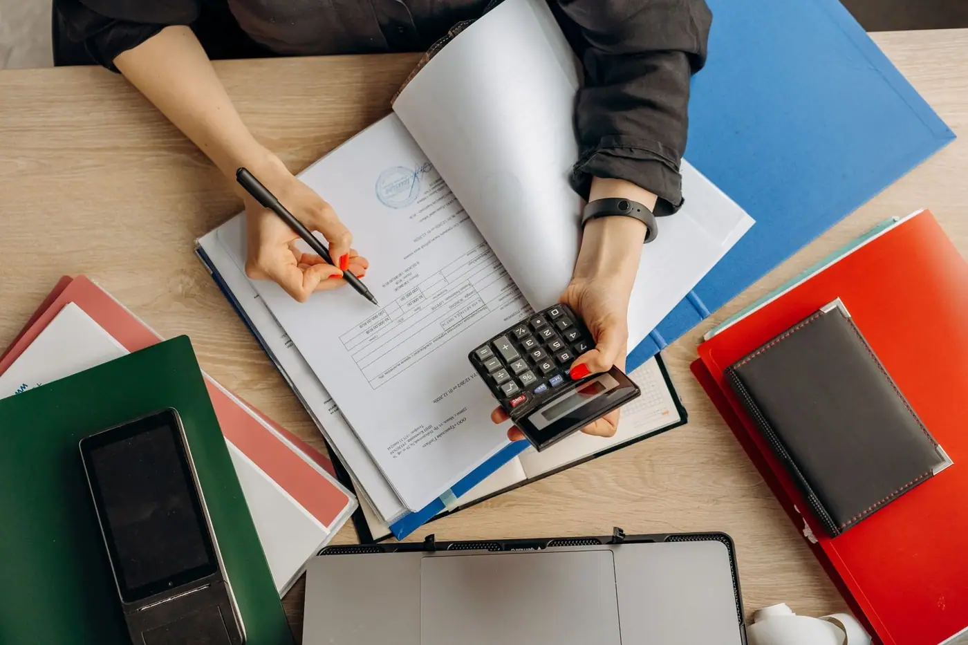 Accountant analysing financial documents with a calculator on a desk