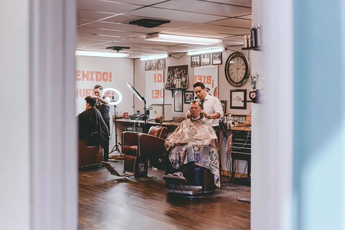 Barbers cutting the hair of clients seated in a traditional barbershop