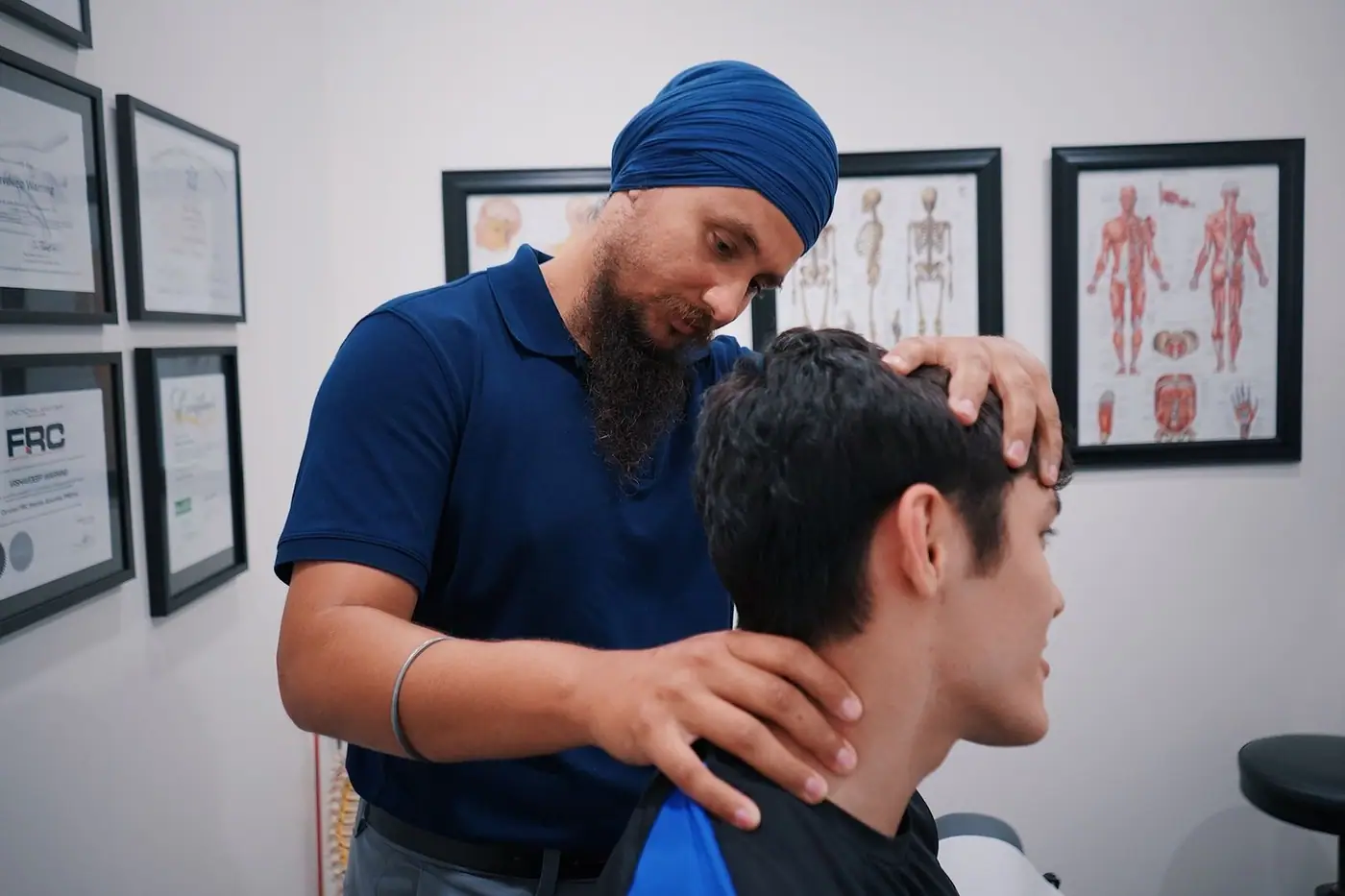 A physiotherapist adjusting a patient's neck in a treatment room