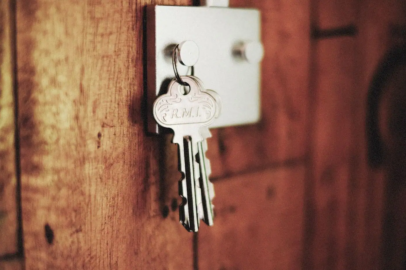 Keys hanging in a door lock on a wooden surface