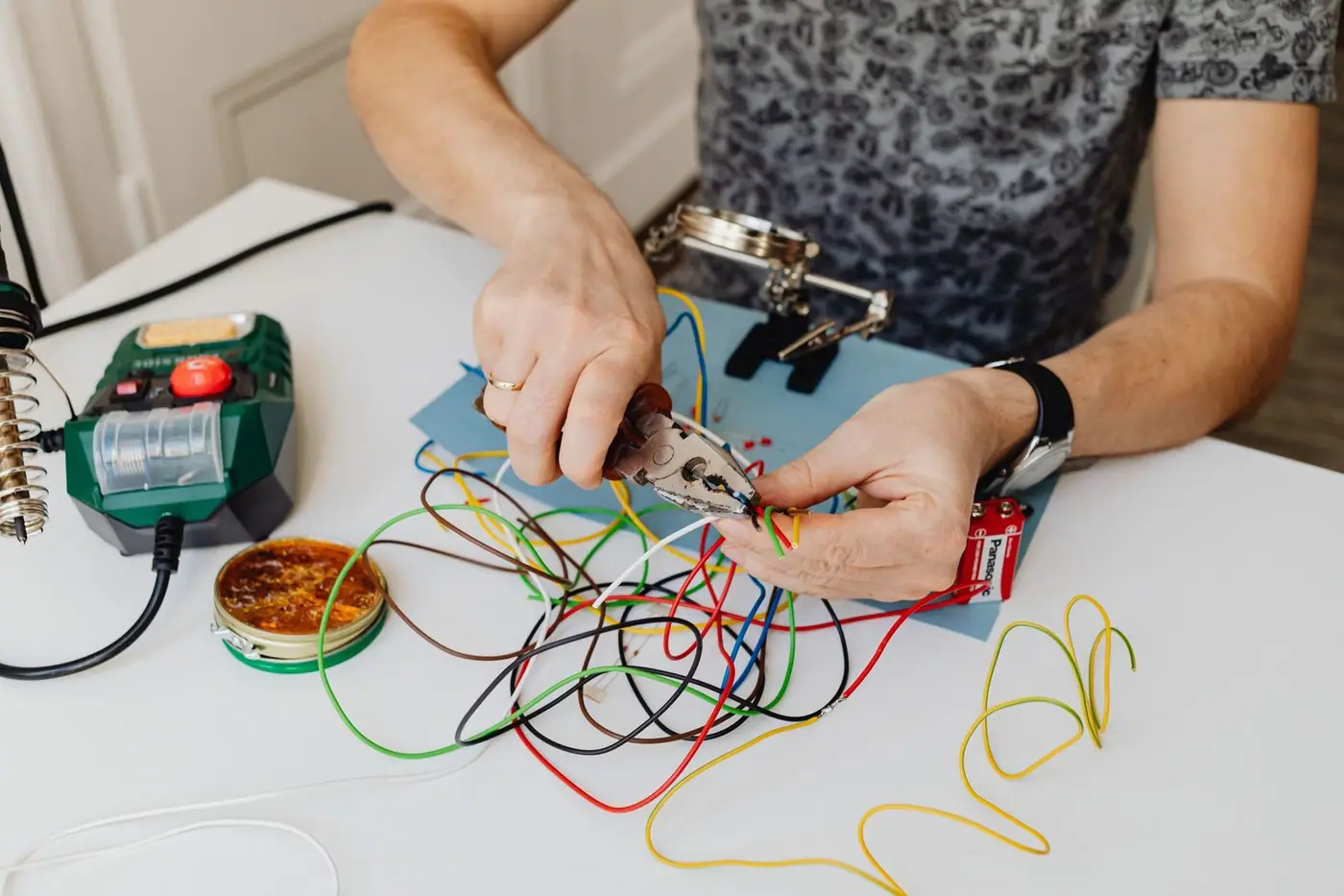 A technician cutting and organising colourful wires with pliers