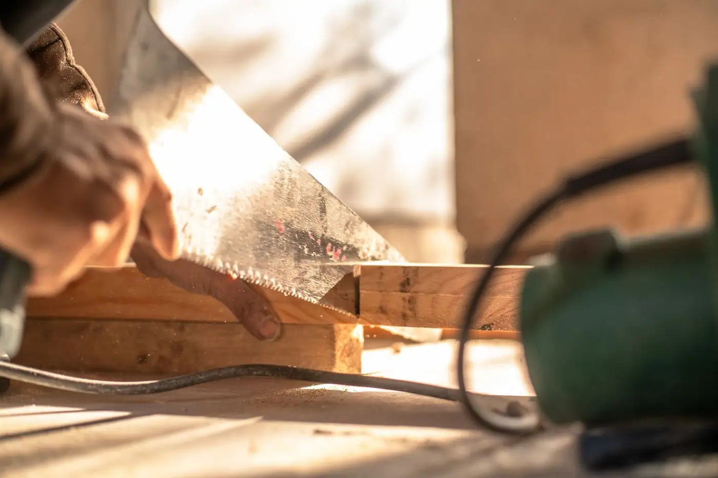 A carpenter cutting wood with a hand saw