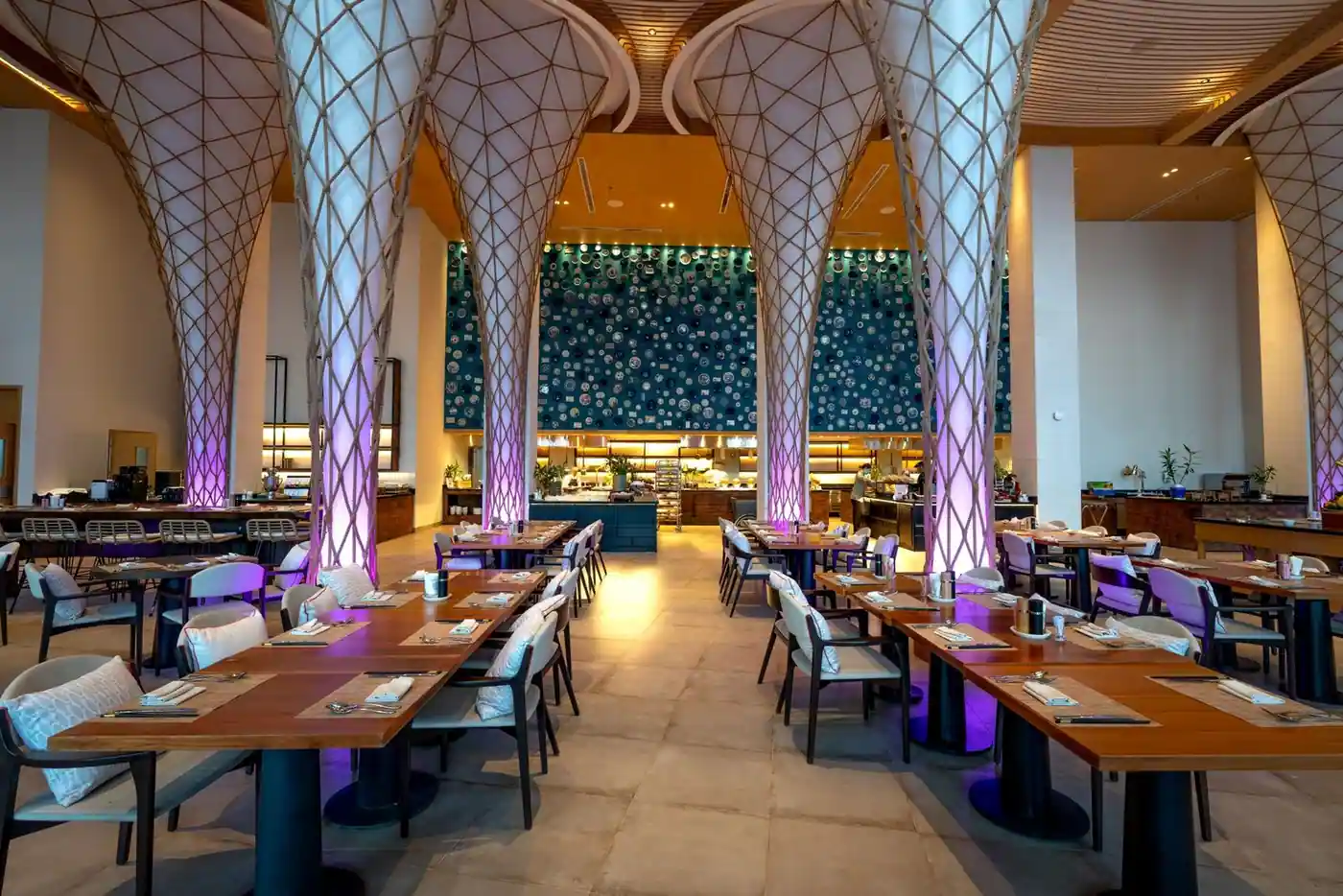 A spacious, modern restaurant interior with illuminated columns and elegant decor