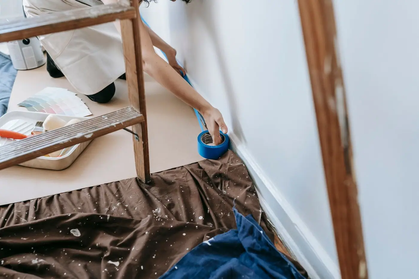 A room being prepared for painting with adhesive tape and tools.