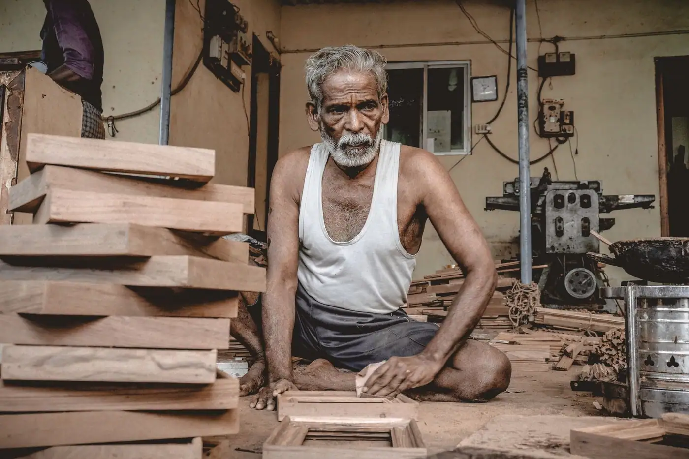 A senior craftsman woodworking in a traditional carpentry workshop