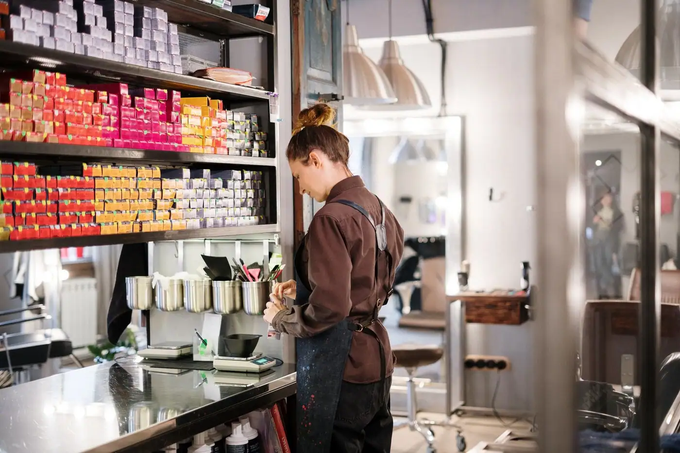 Hair colour products being arranged on a salon shelf