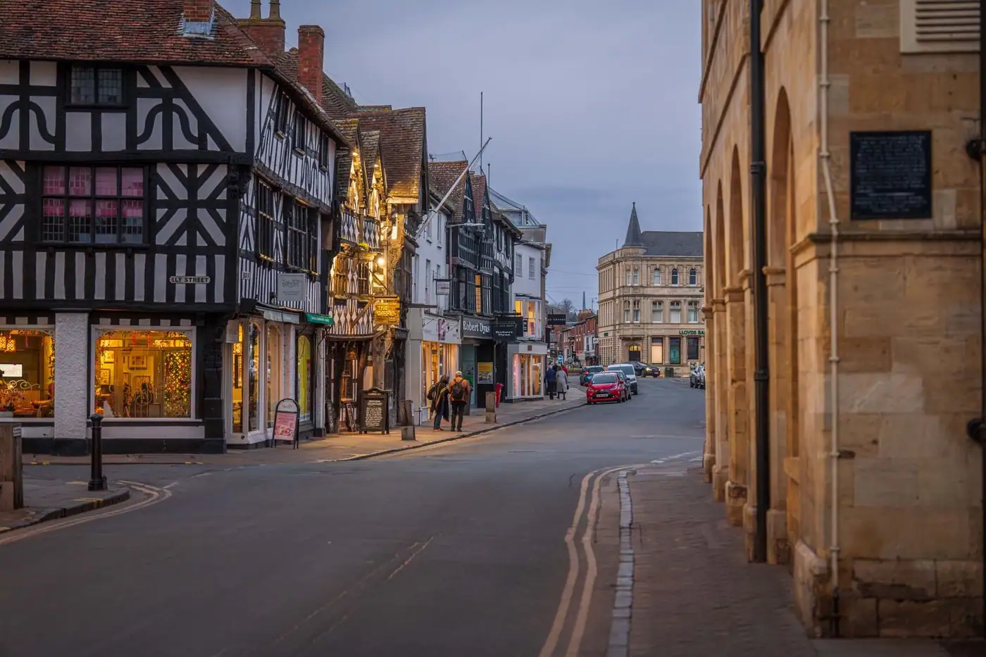 Street of Tudor-style buildings in a historic town at dusk