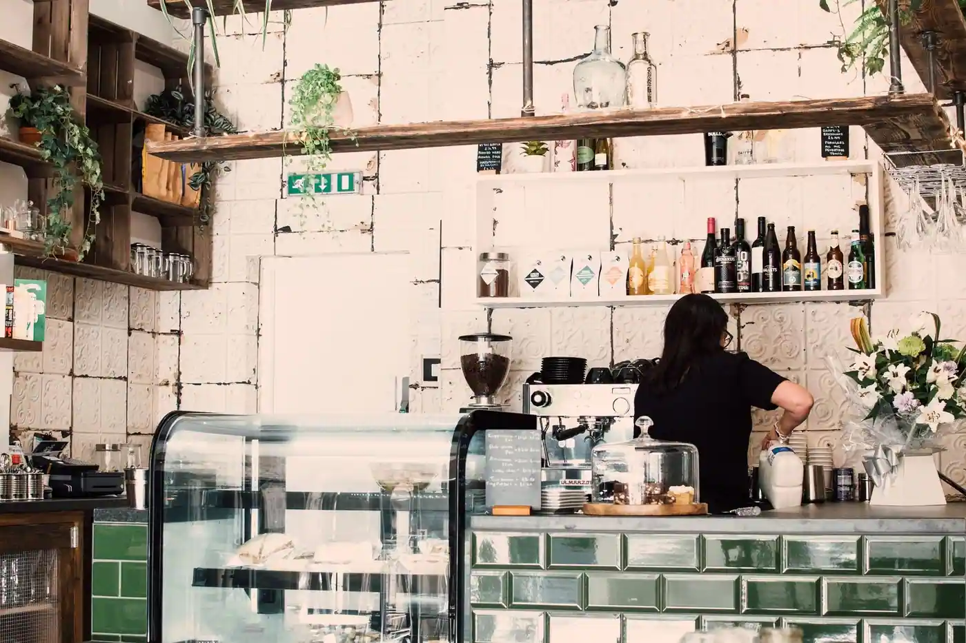 A cafe interior with a barista preparing coffee behind the counter