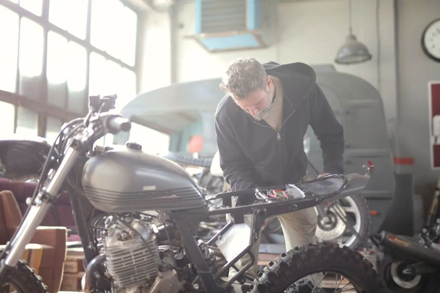 Man working on a motorcycle inside a workshop