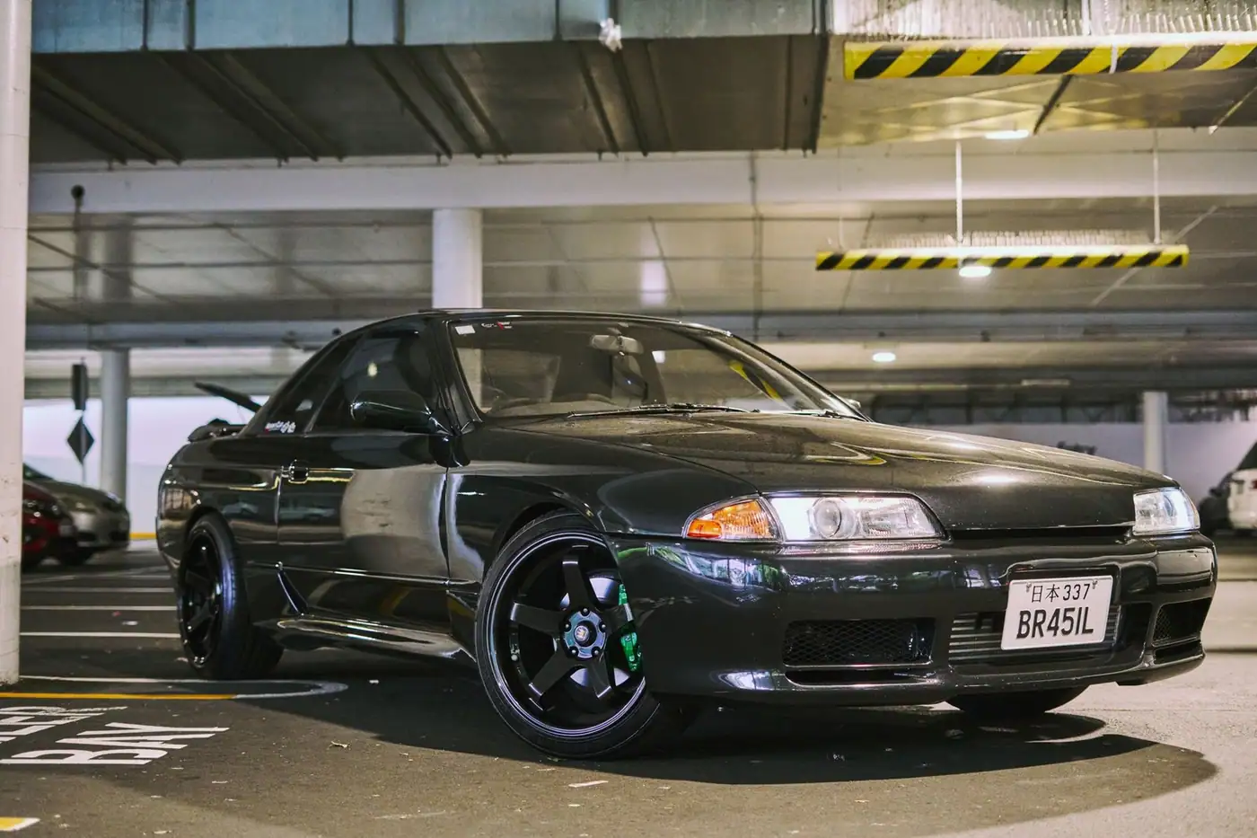 A modified car with a sleek design in an underground parking garage