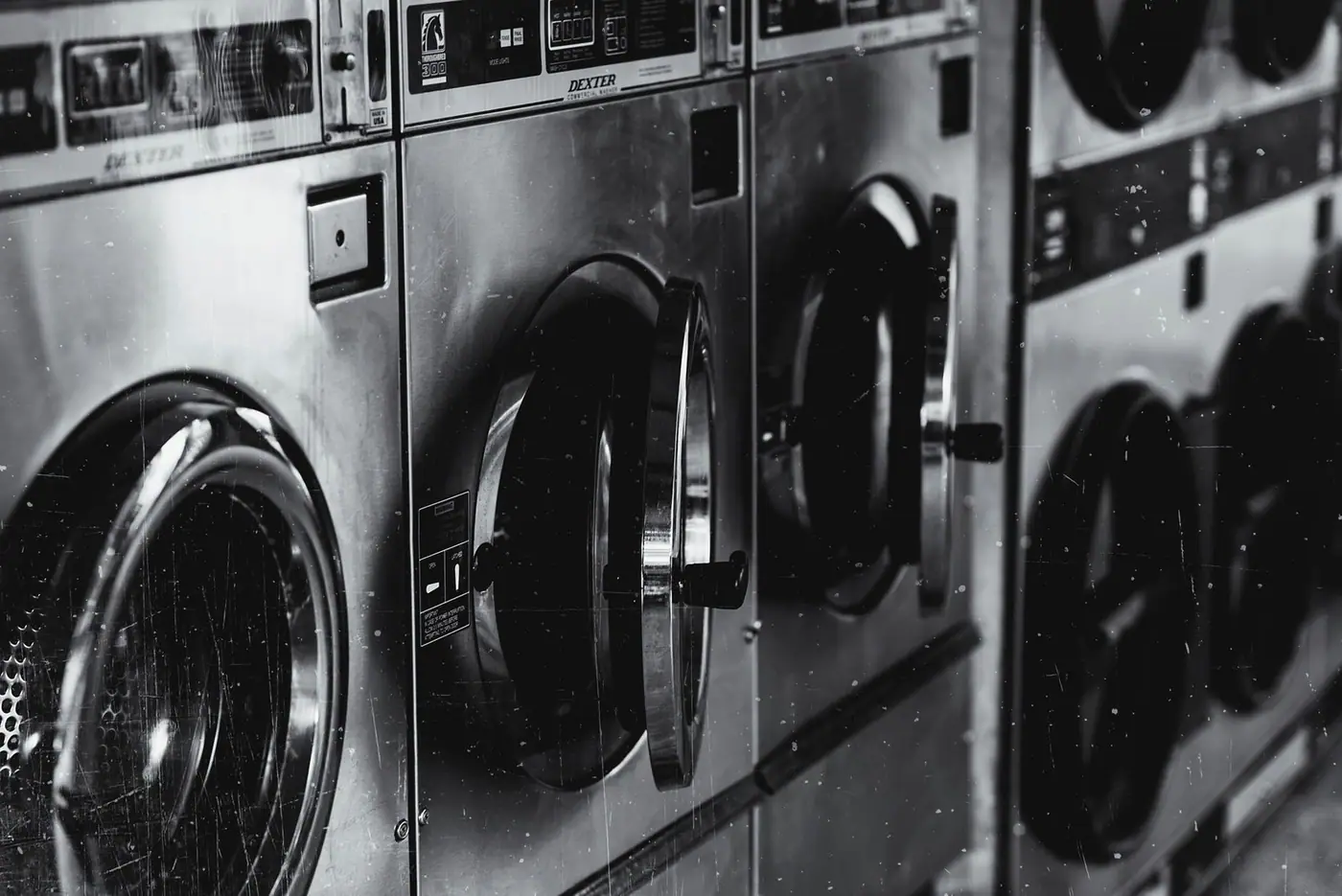 Industrial washing machines in a retro style laundry facility.