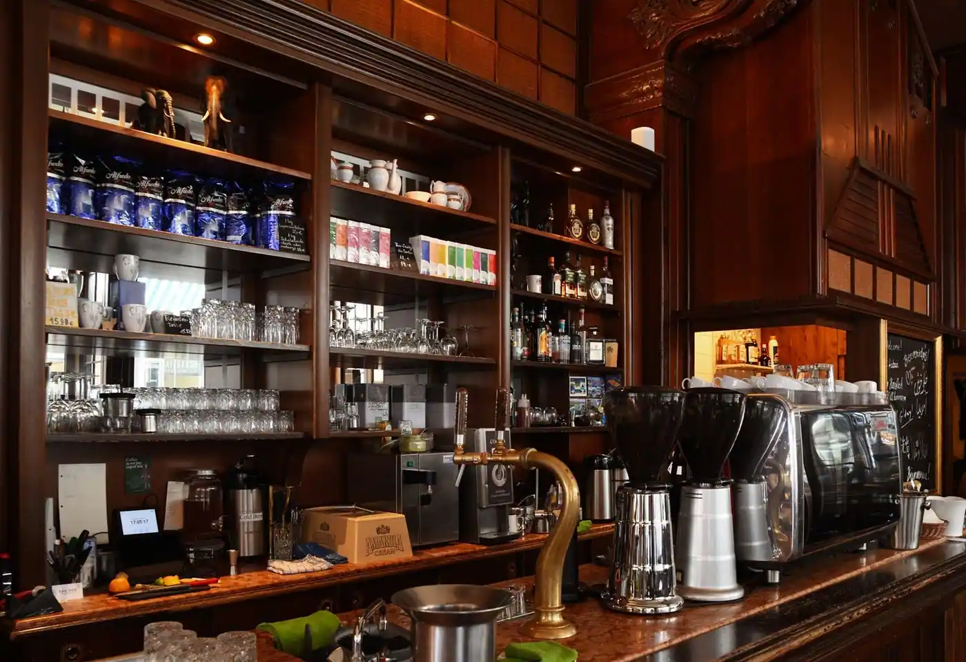 Elegant coffee shop counter displaying an espresso machine and various drinks.