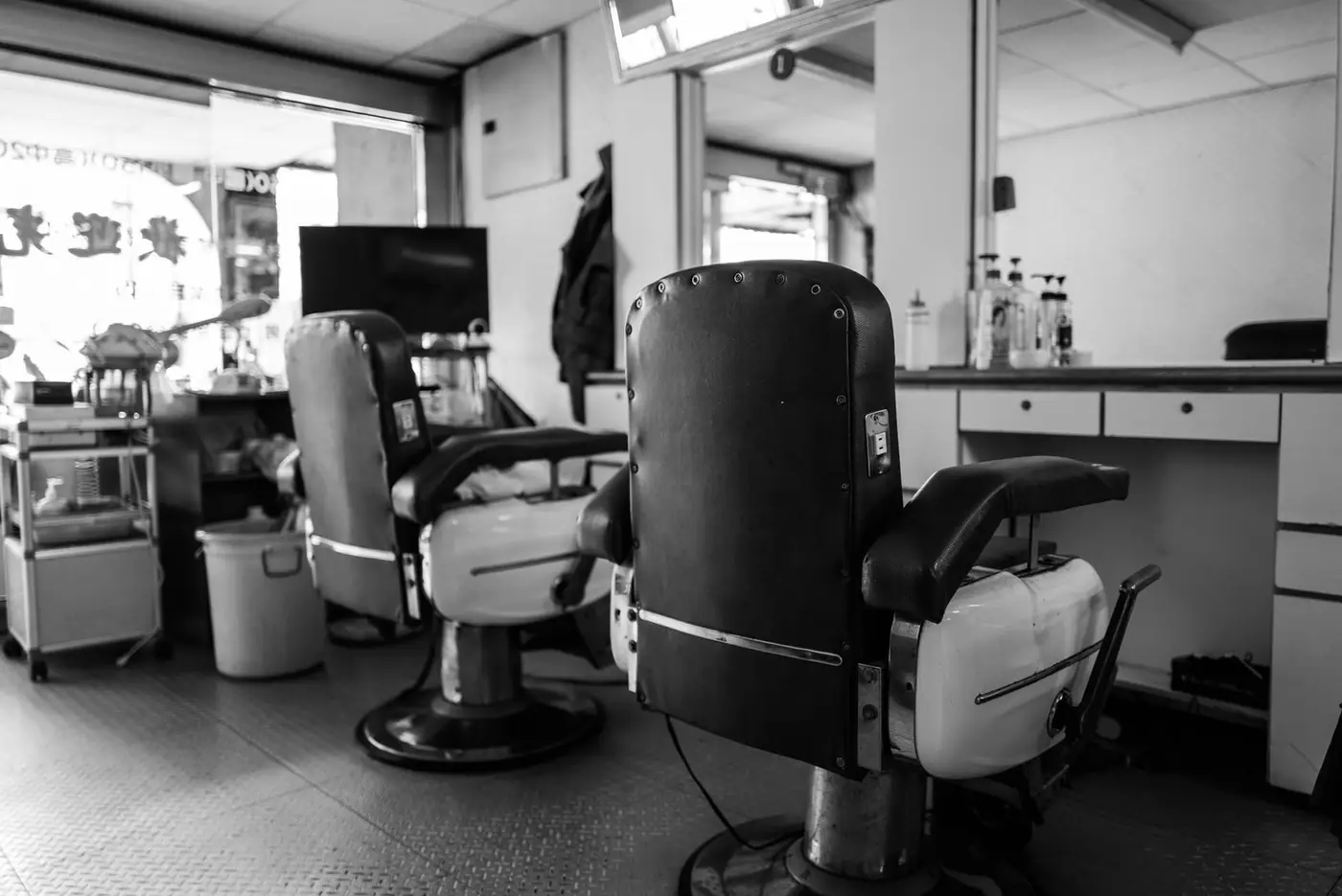 A vintage barbershop interior with classic barber chairs and mirrors in black and white.