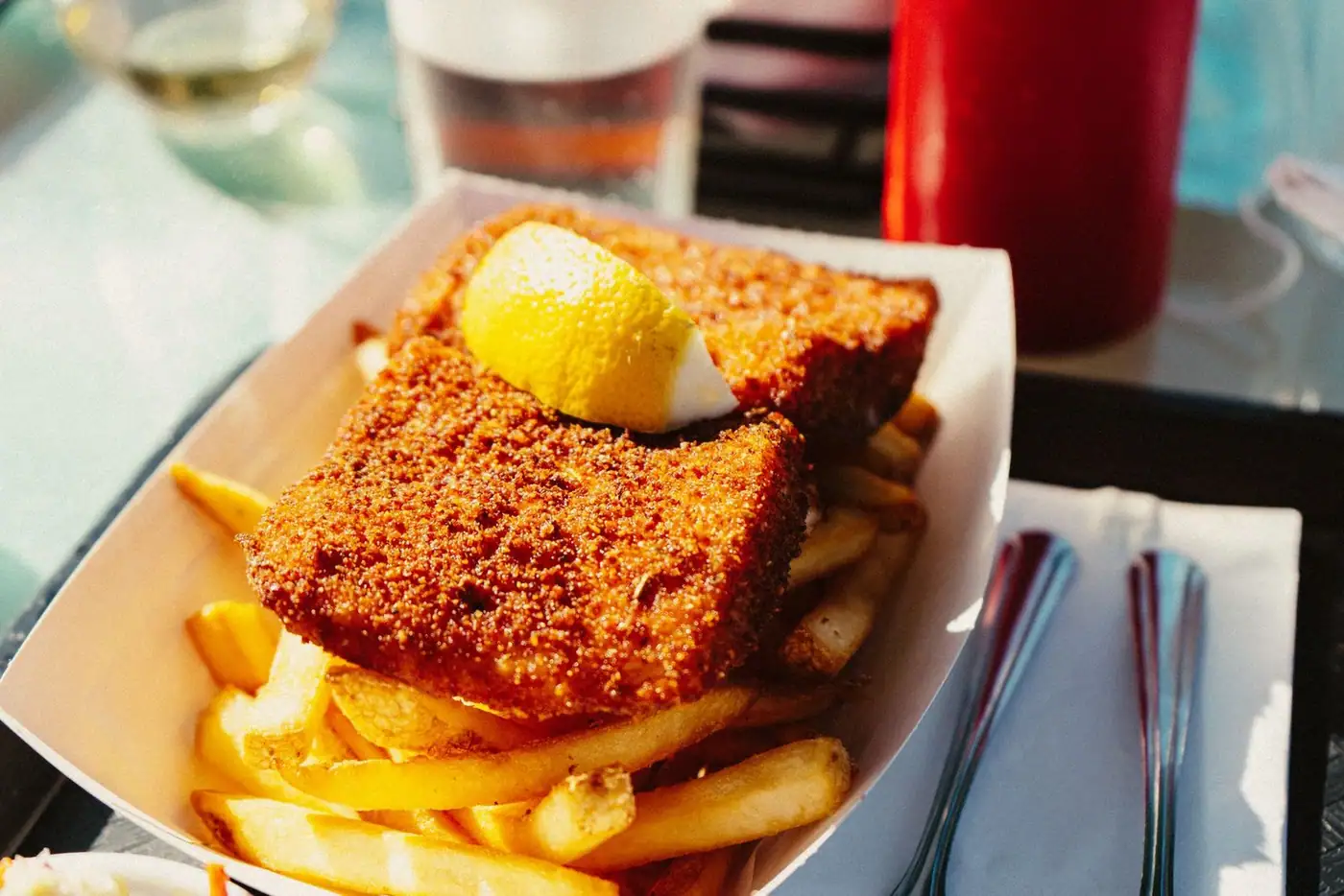 Close-up of crispy chips and fried food with a lemon wedge