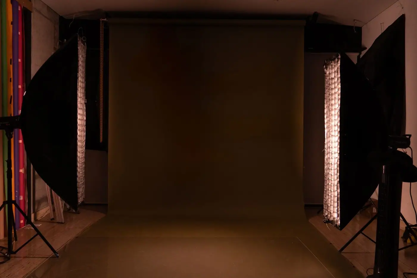 A sleek and modern photography studio setup featuring a mocha backdrop and professional lighting equipment