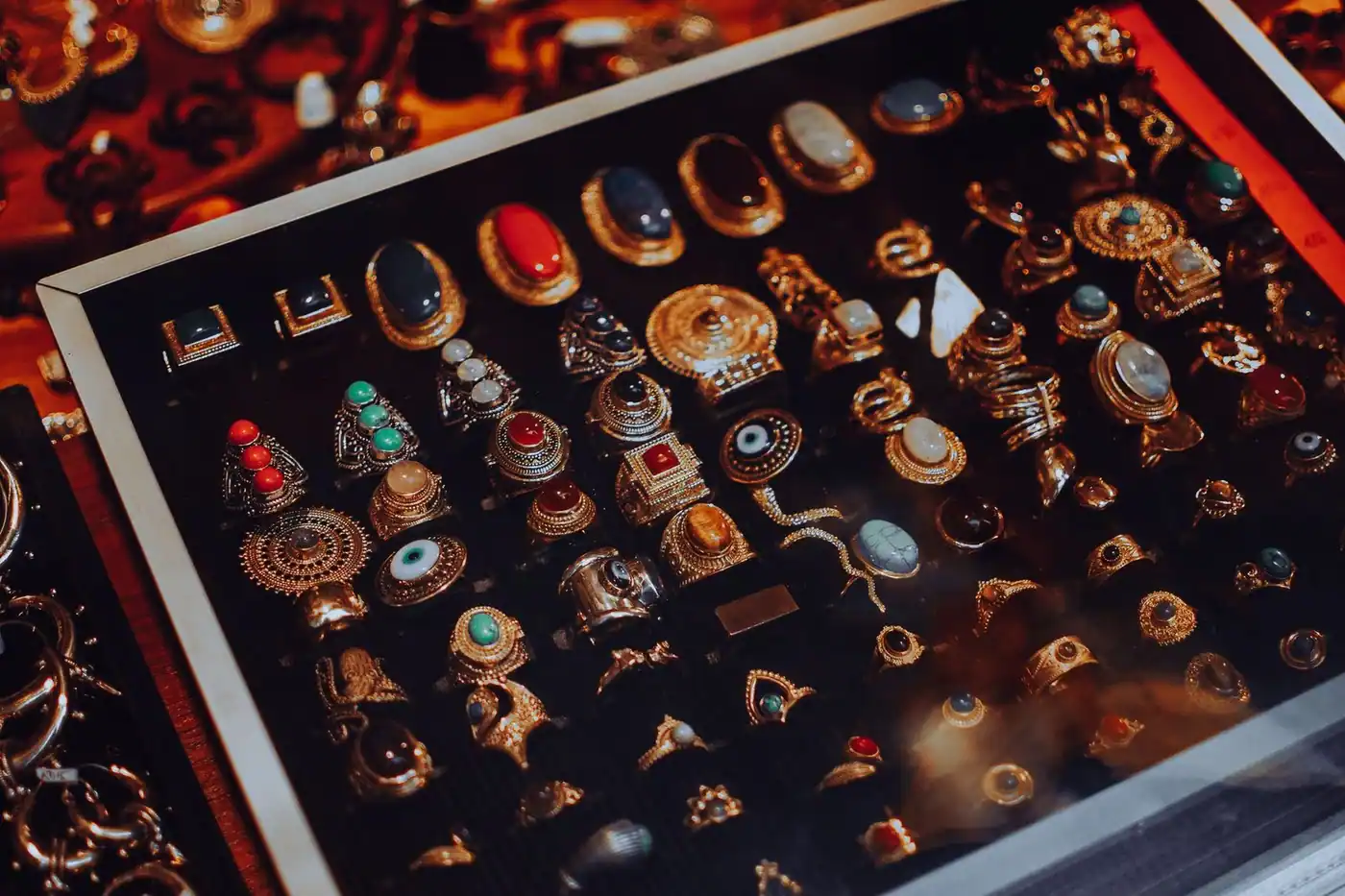 Vintage-style jewellery with ornate designs in a glass display case