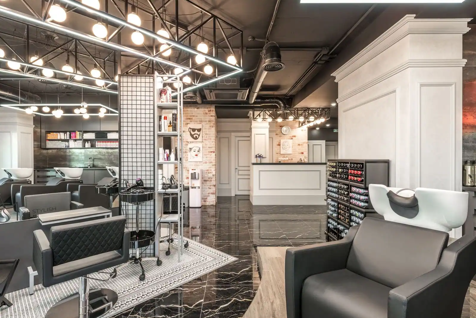 Backwash chair with sink placed near shelves with cosmetology products and reception desk in stylish beauty salon with d