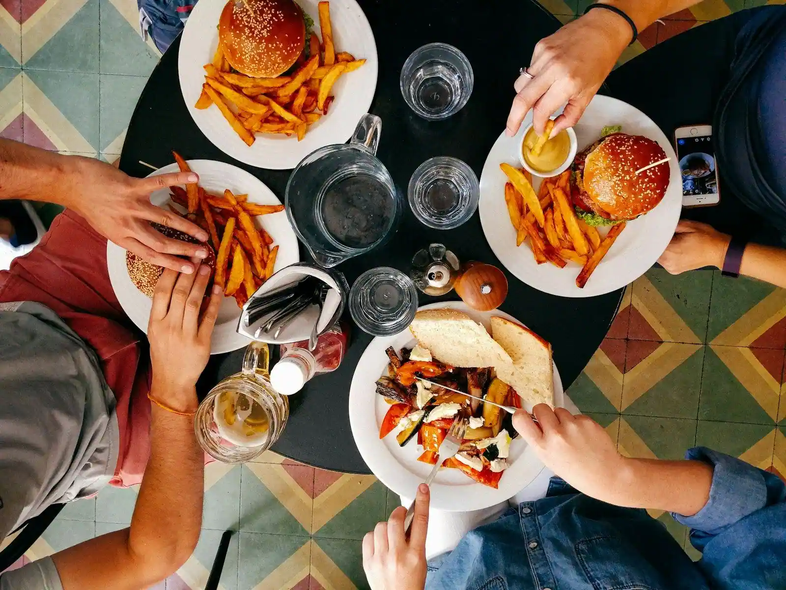 Overhead view of a group meal on a colorful tiled table