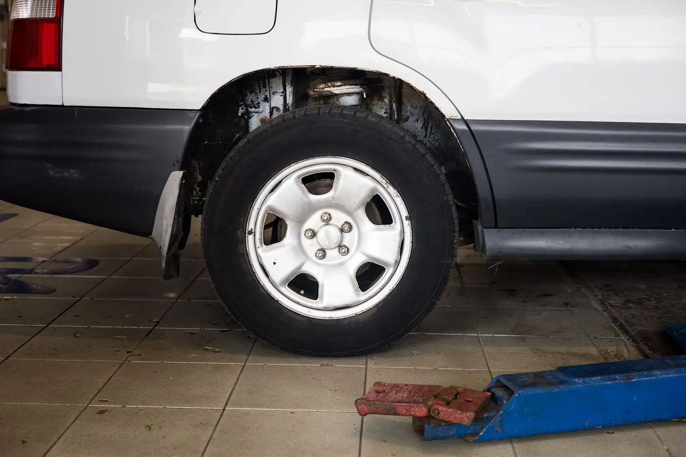 Close-up of a car wheel raised on a hydraulic jack, ready for a tyre change