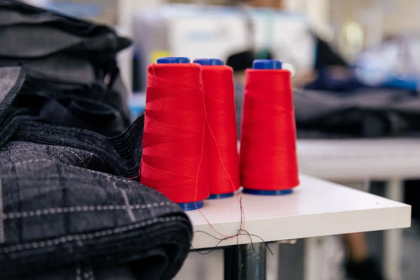 Vibrant red thread spools on a table in a tailoring room