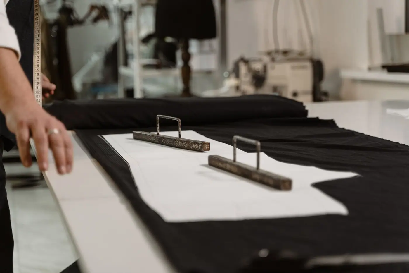 Close-up of a tailor measuring fabric with a tape