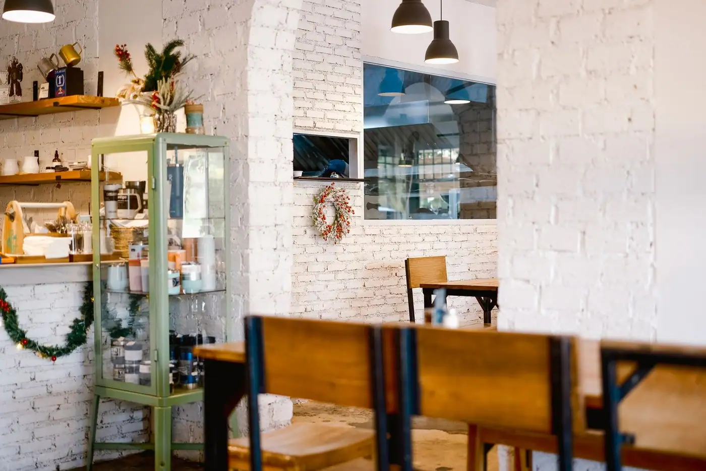 Quiet modern café interior with rustic decor, festive wreath and warm lighting