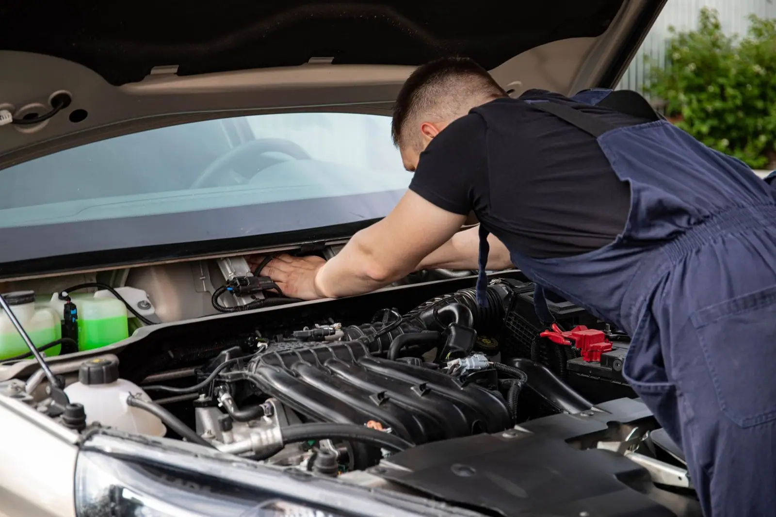Auto mechanic performs engine maintenance on a car