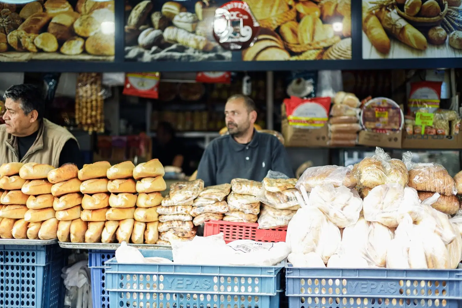 Vibrant market scene with two men selling assorted breads at an outdoor stall